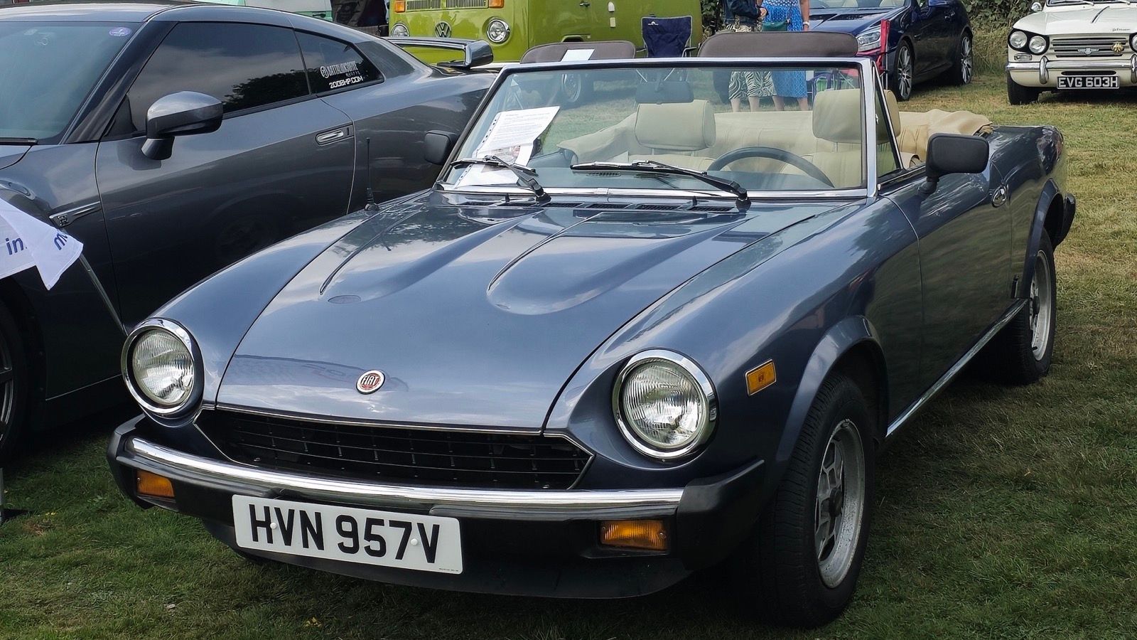 Blue-grey 1980 Fiat 124 Sport Spider with the top down, front three-quarter view