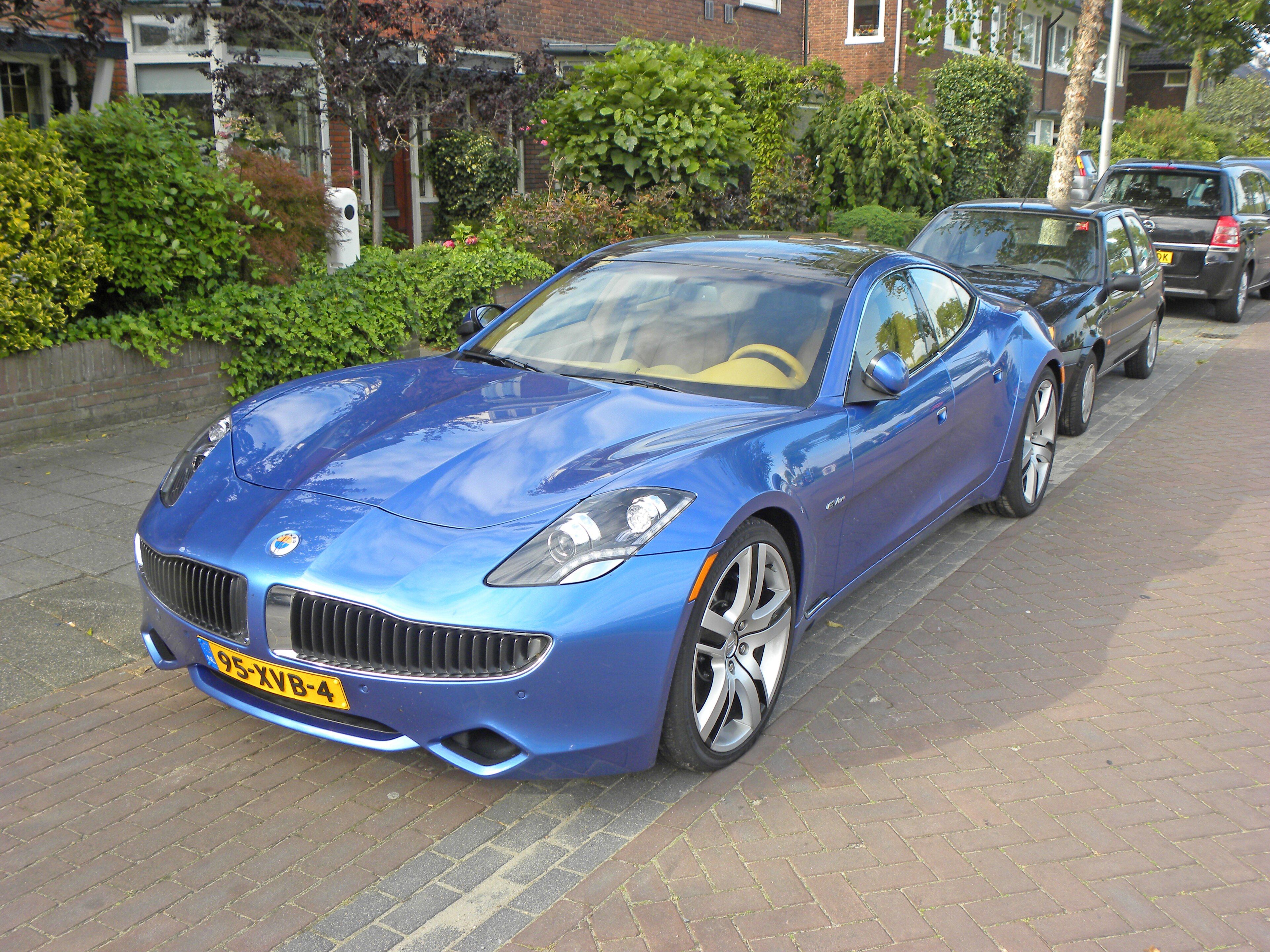 Blue 2012 Fisker Karma plug-in-hybrid sedan parked on a street, front three-quarter view