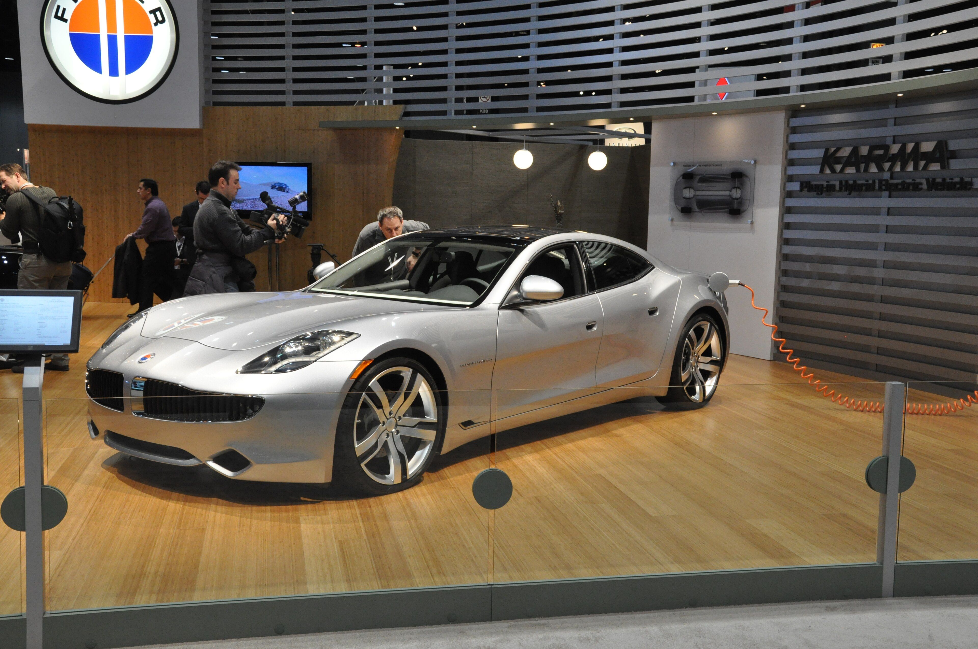 Silver Fisker Karma plug-in-hybrid sedan on display, front three-quarter view