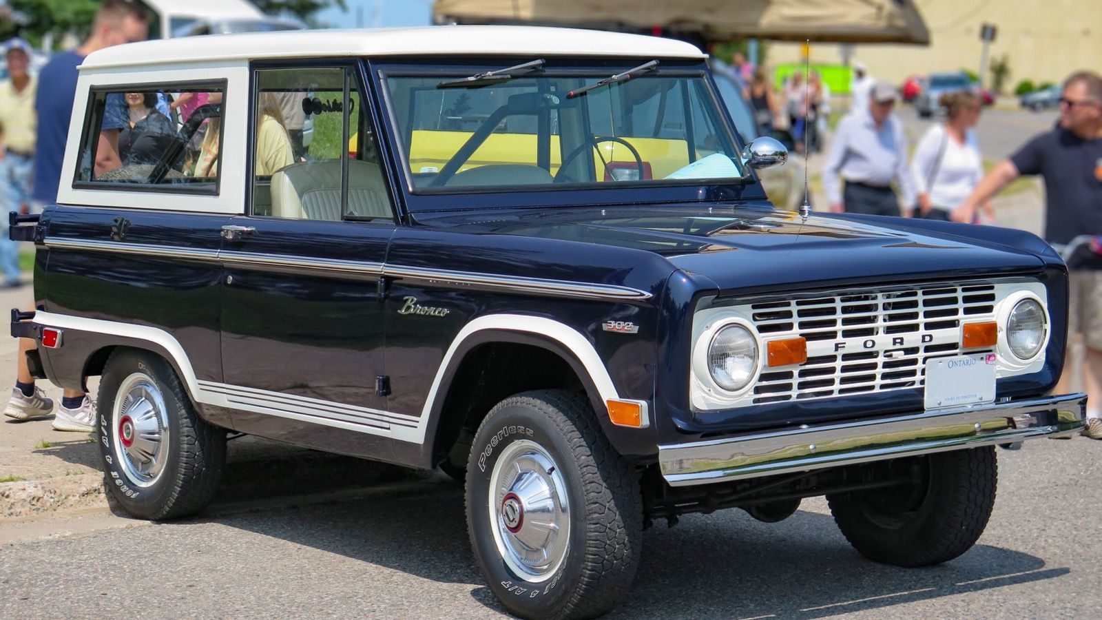 1969 Ford Bronco wagon, first-generation compact 4x4 — navy blue and white, front three-quarter view