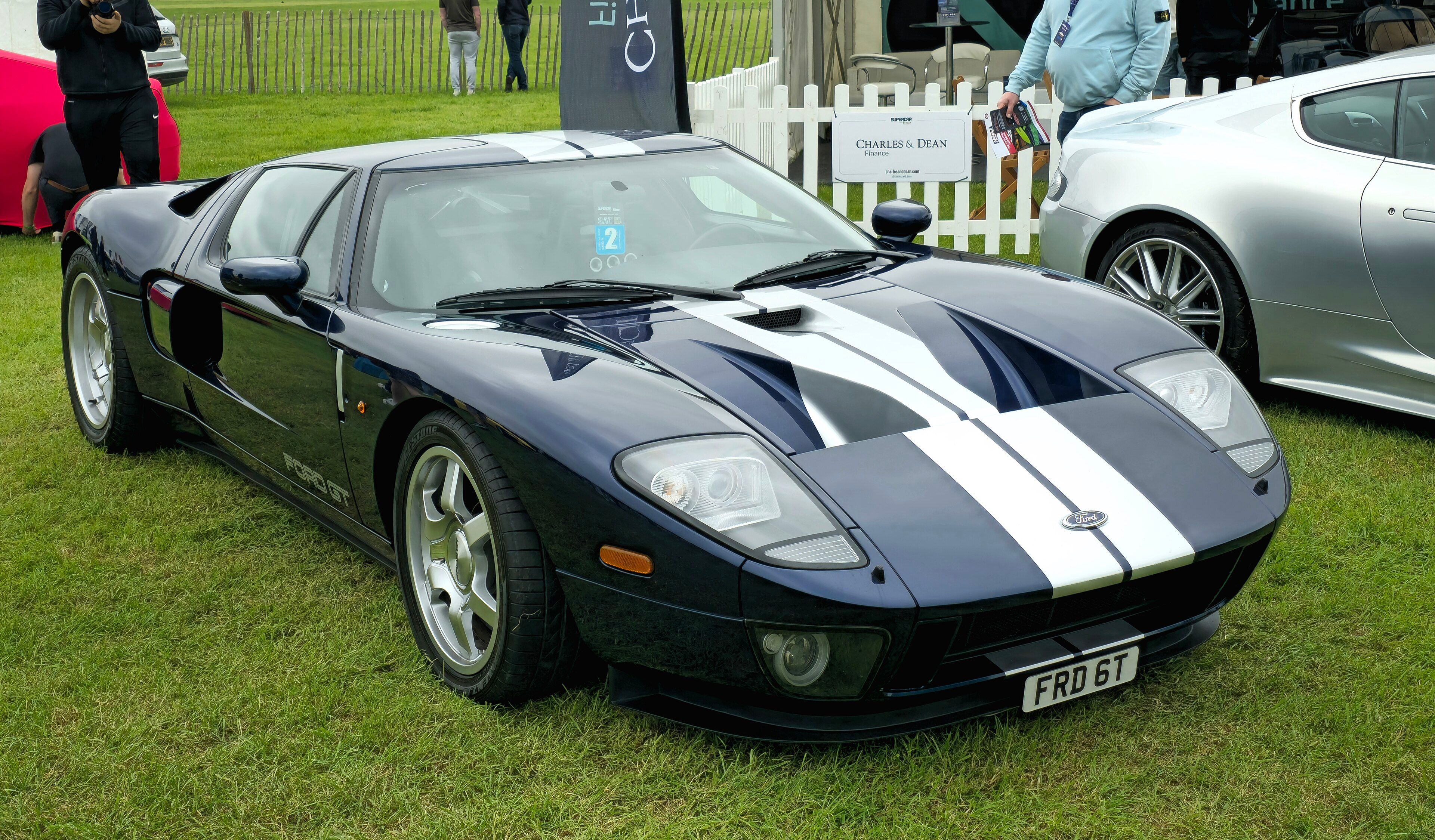 Dark blue 2005 Ford GT with white racing stripes, front three-quarter view