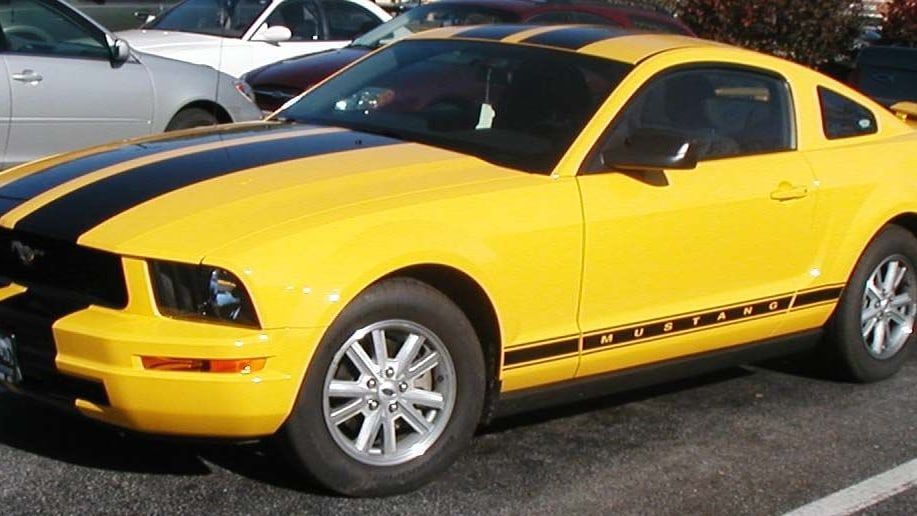 2005 Ford Mustang, fifth generation S197 — yellow coupe with racing stripes, front three-quarter view