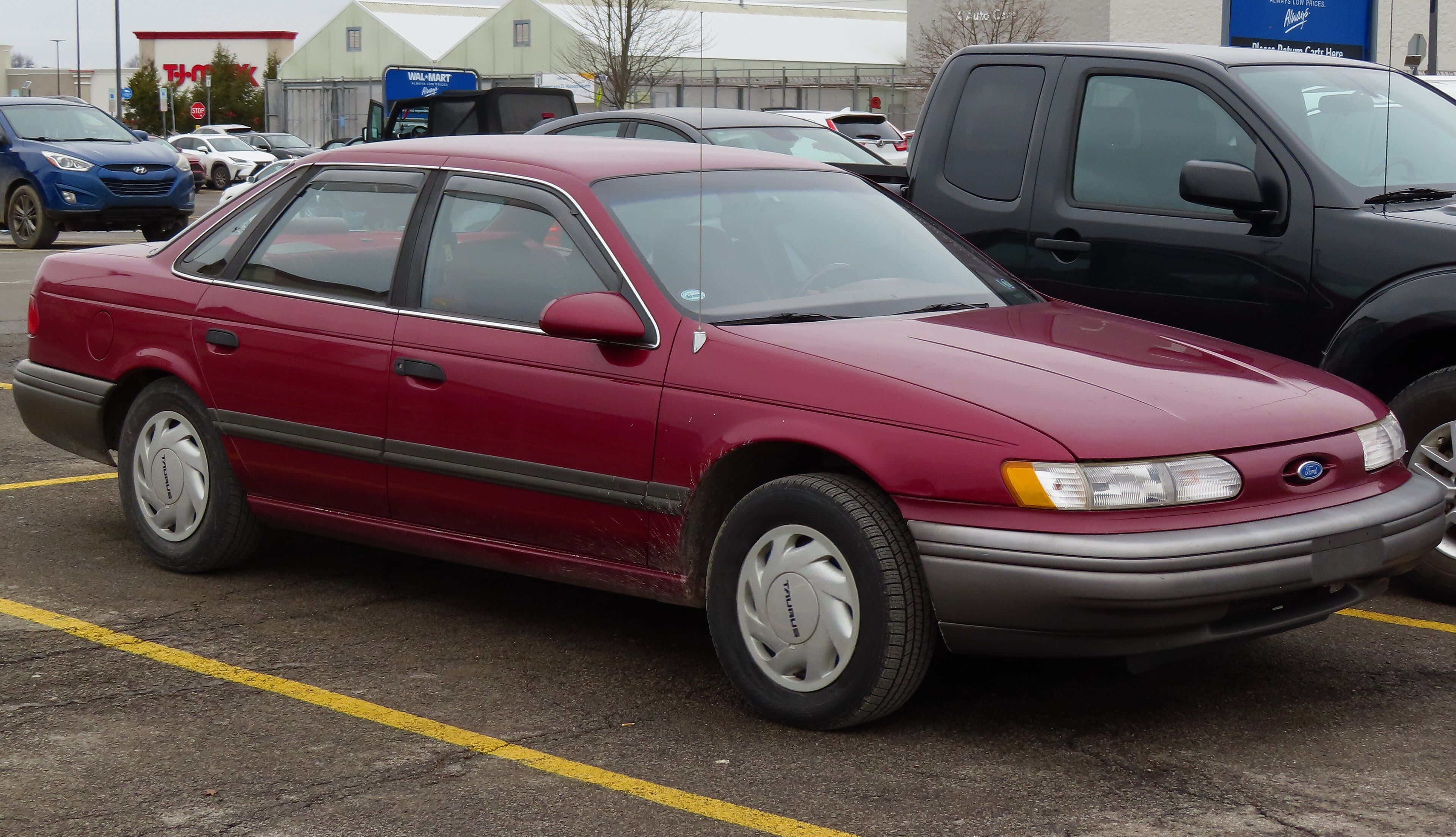 Red 1992 Ford Taurus GL four-door sedan, front three-quarter view