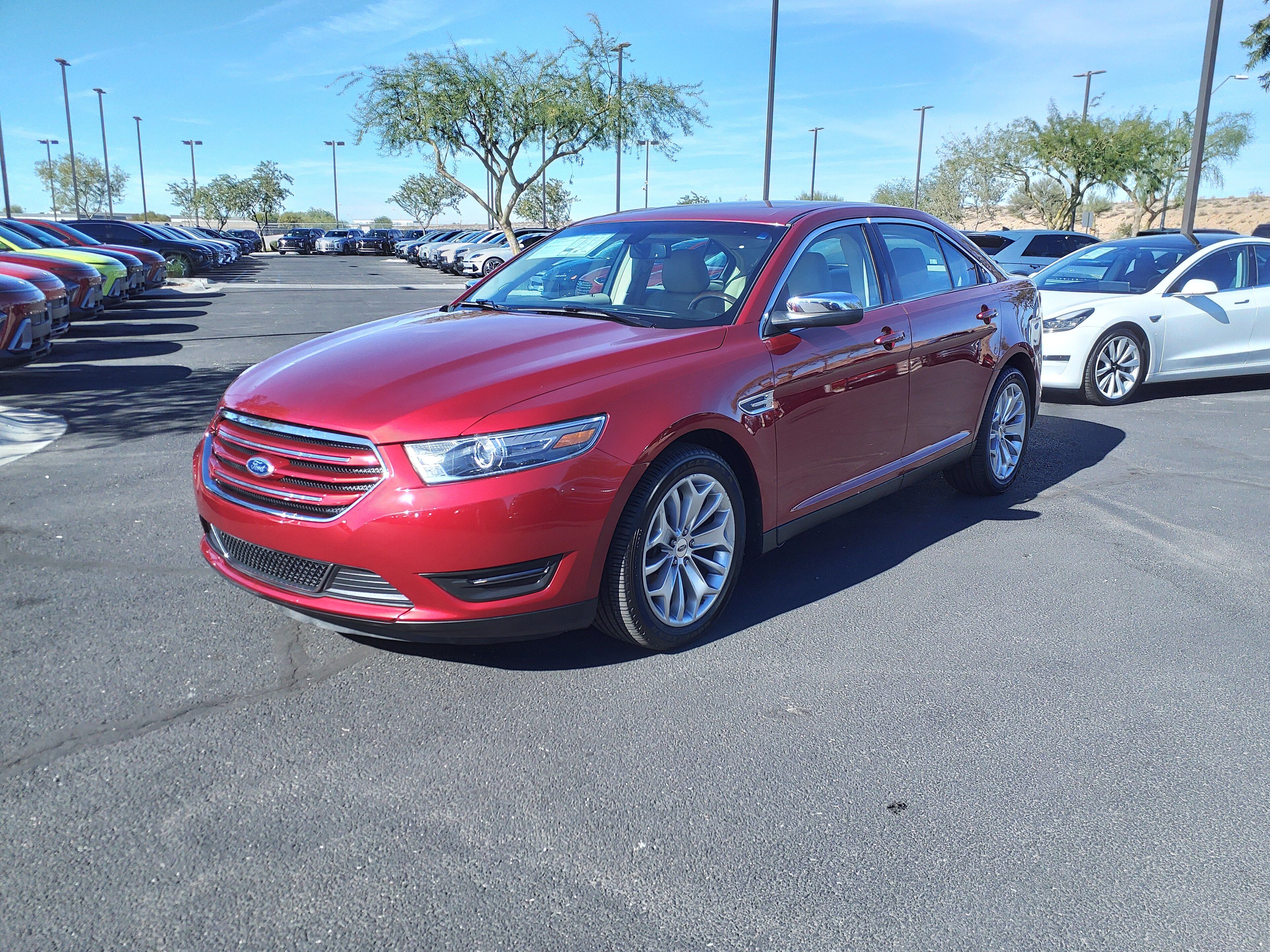 Red 2015 Ford Taurus Limited full-size sedan, front three-quarter view