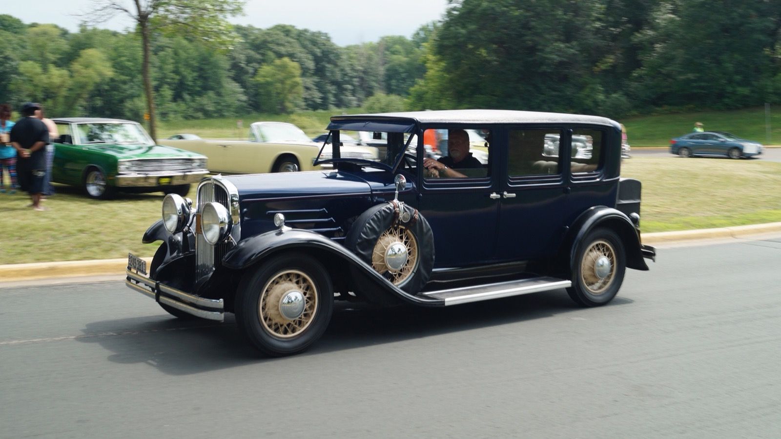Dark blue 1930 Franklin four-door sedan with sidemount spare, front three-quarter view