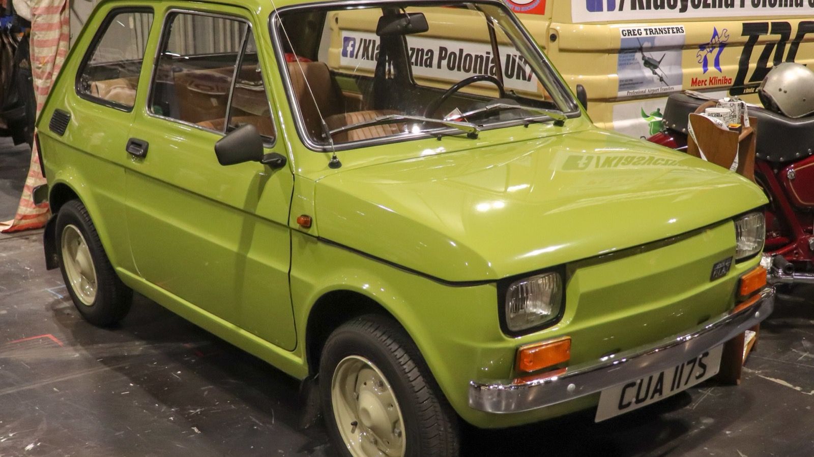 Green 1978 Polski Fiat 126p 650 with chrome bumpers on indoor display, front three-quarter view
