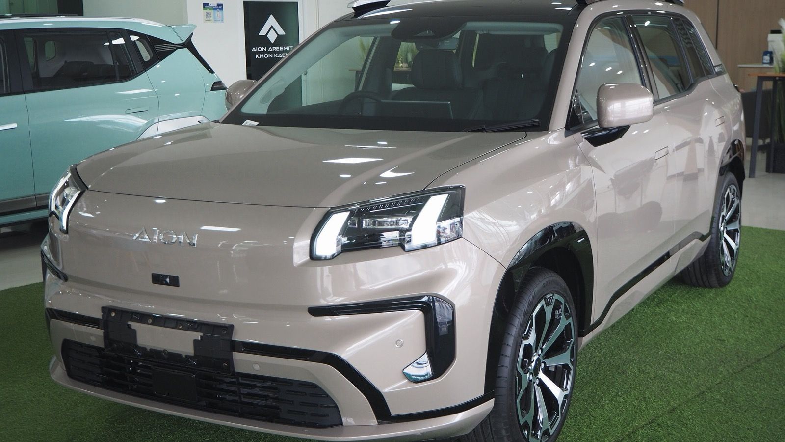 Beige second-generation GAC Aion V in a showroom, front three-quarter view