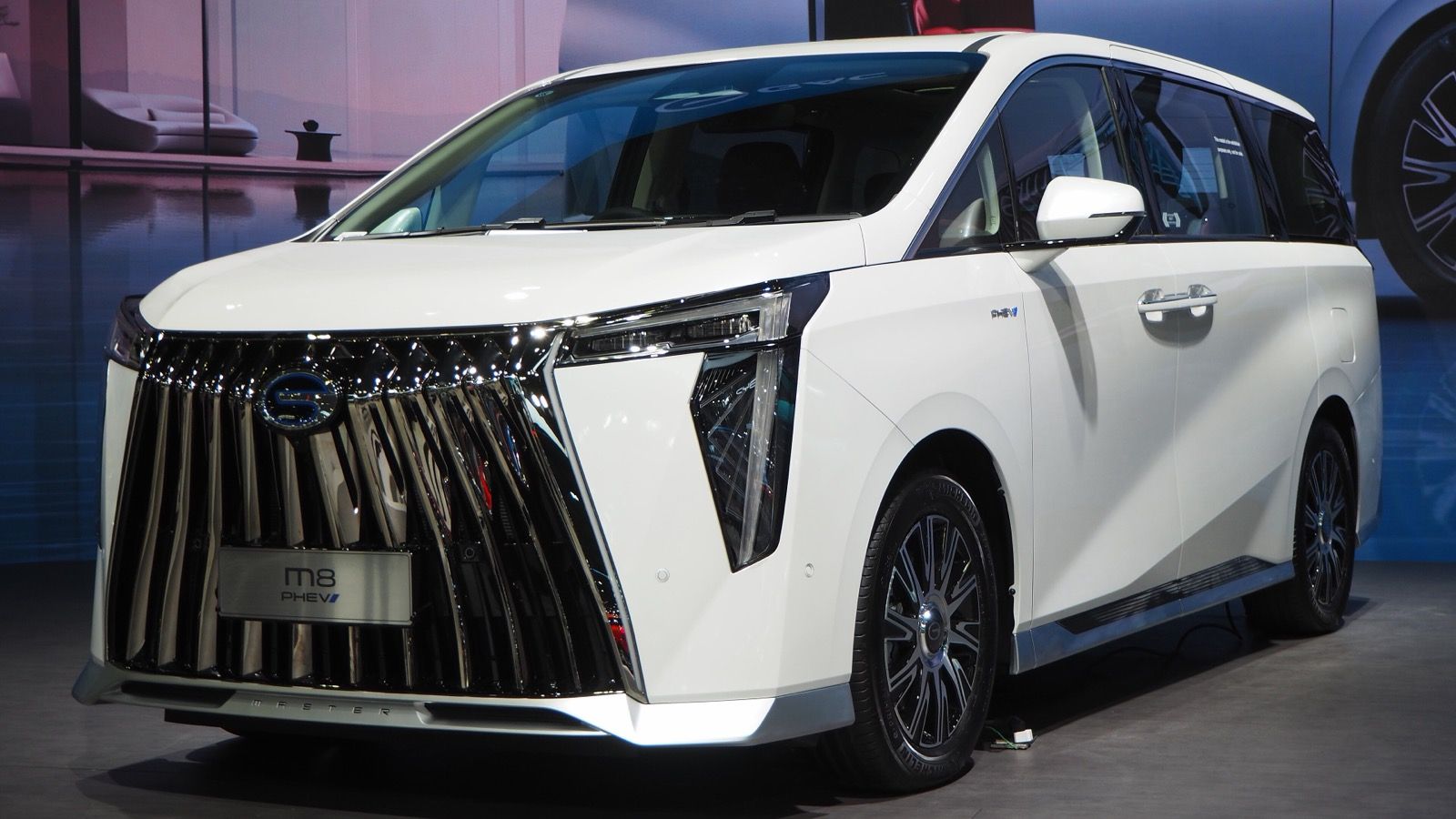 White 2025 GAC M8 PHEV on a show stand, front three-quarter view
