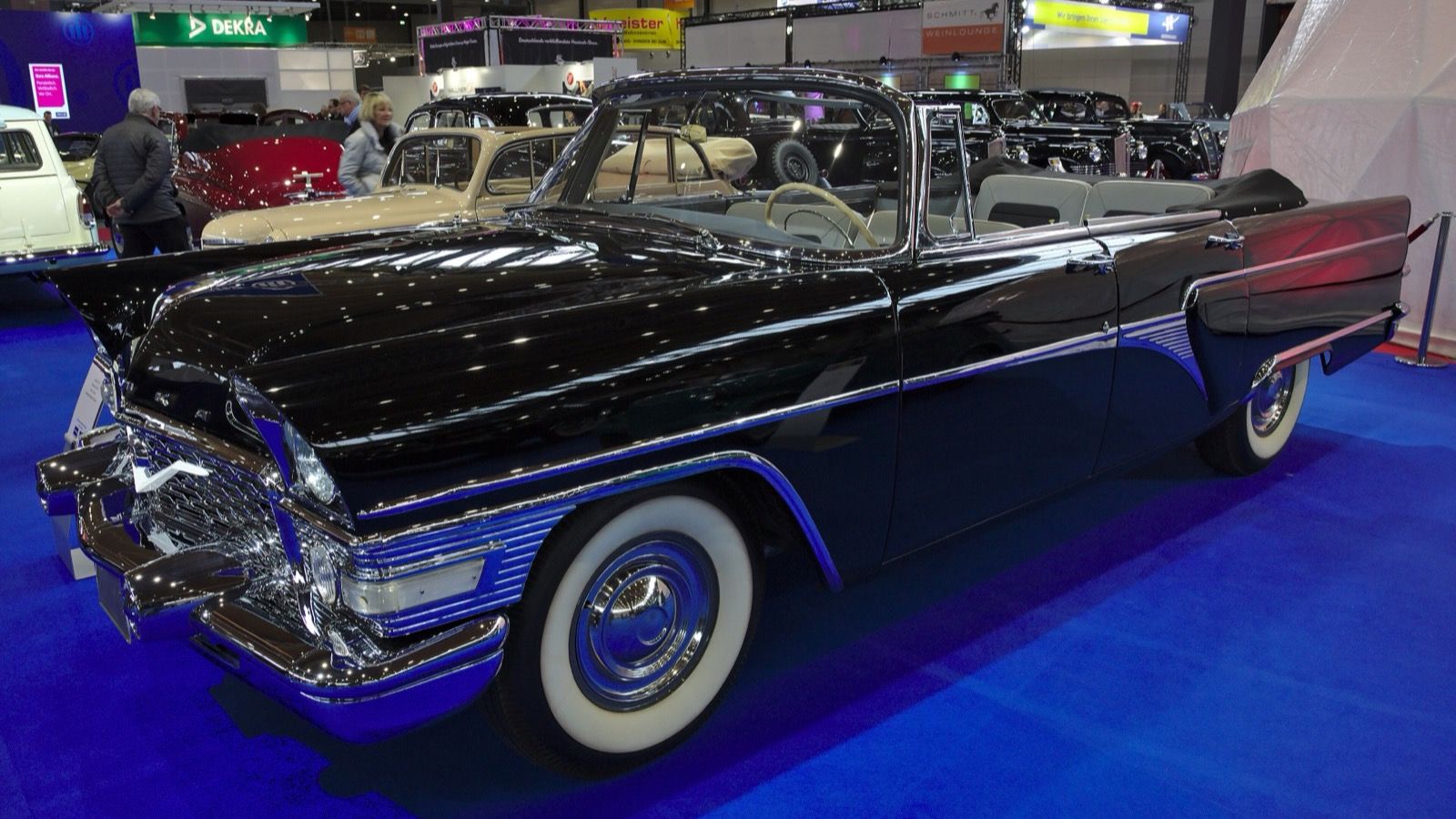 Black 1968 GAZ-13B Chaika four-door cabriolet with the top down at an indoor show, front three-quarter view