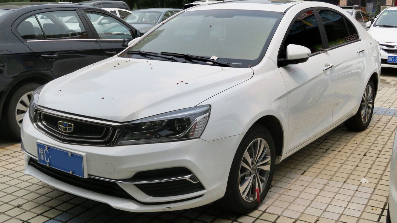 White 2018 Geely Emgrand sedan parked on paving, front three-quarter view
