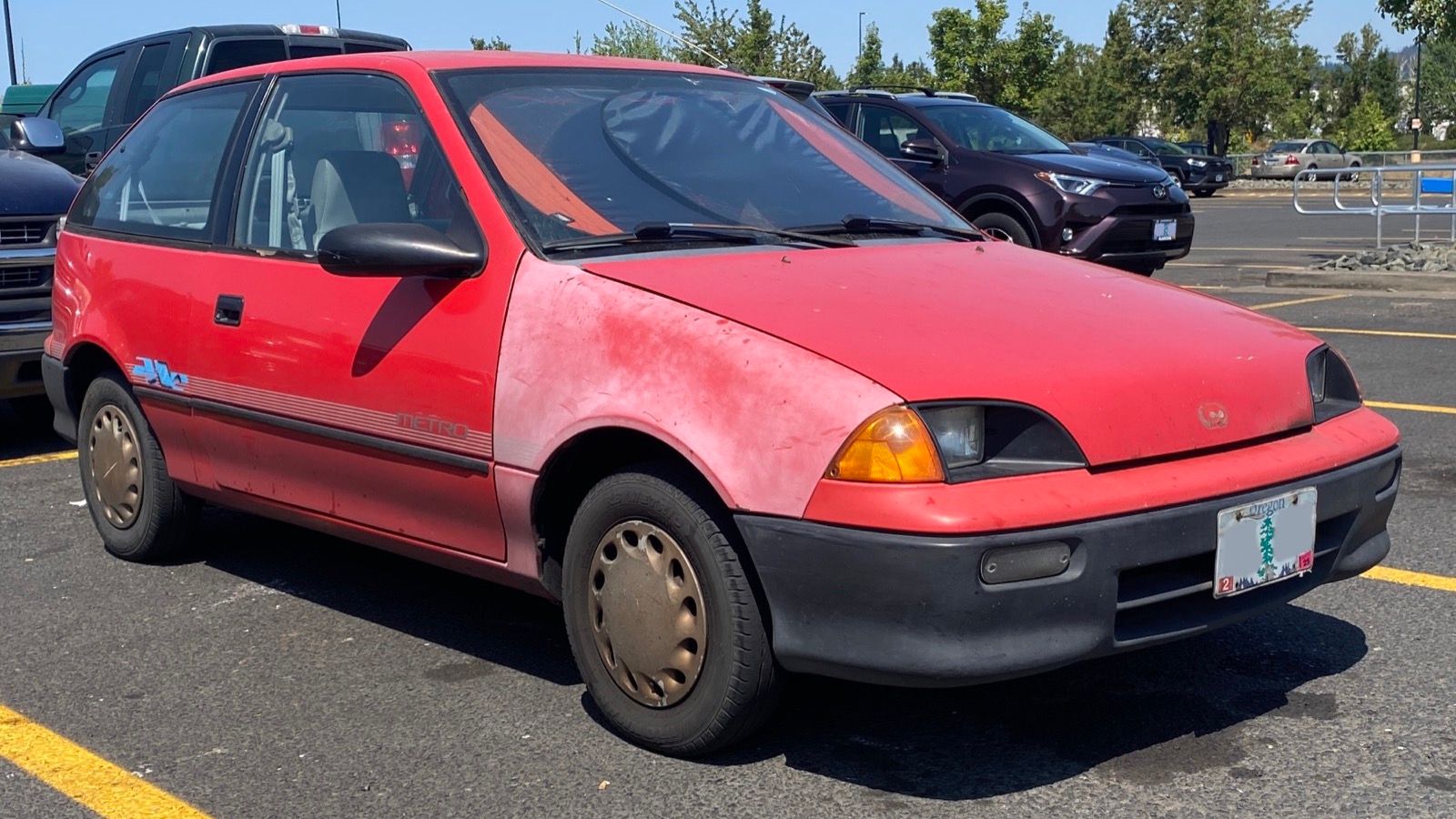 Bright red 1992 Geo Metro two-door hatchback, front three-quarter view
