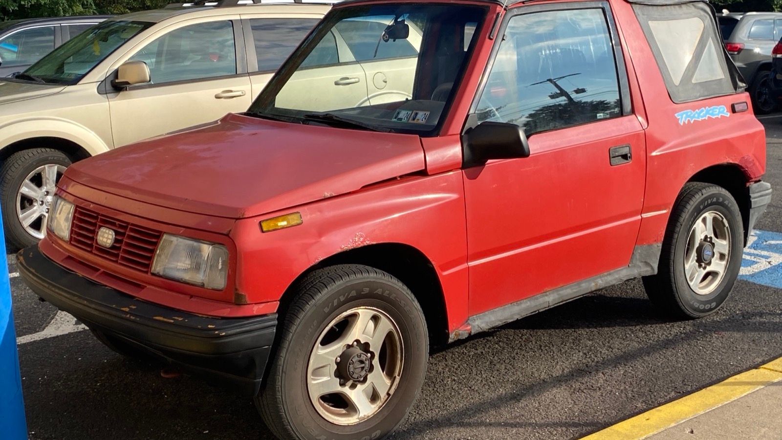 Bright red 1995 Geo Tracker LSi, front three-quarter view