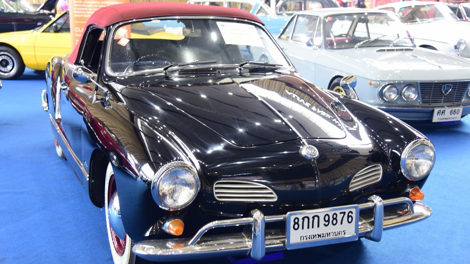 Black 1964 Volkswagen Karmann Ghia cabriolet with a red soft top, front three-quarter view.