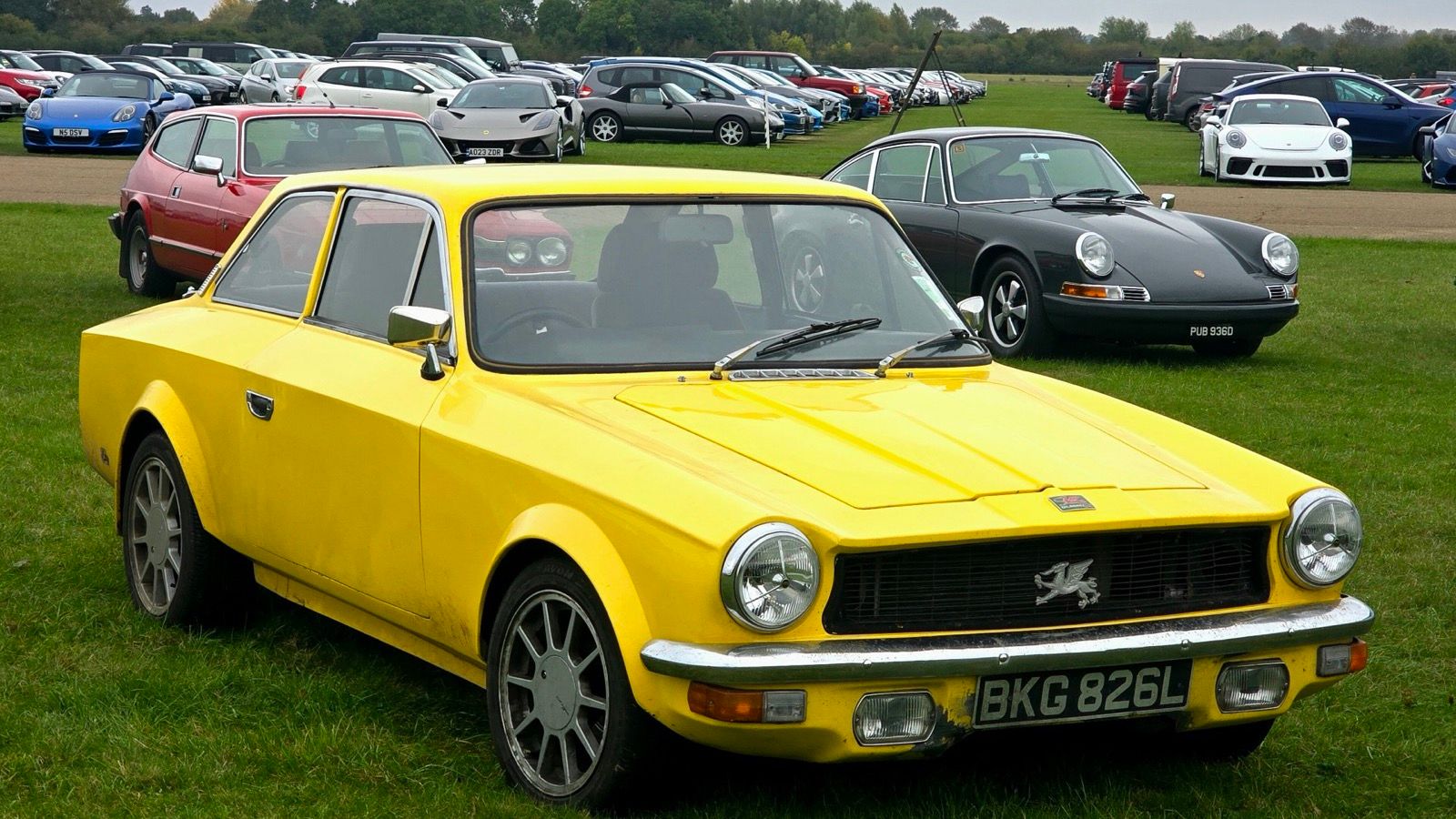 Yellow Gilbern Invader Mk III coupé, front three-quarter view, showing the restyled nose and Welsh dragon grille badge.