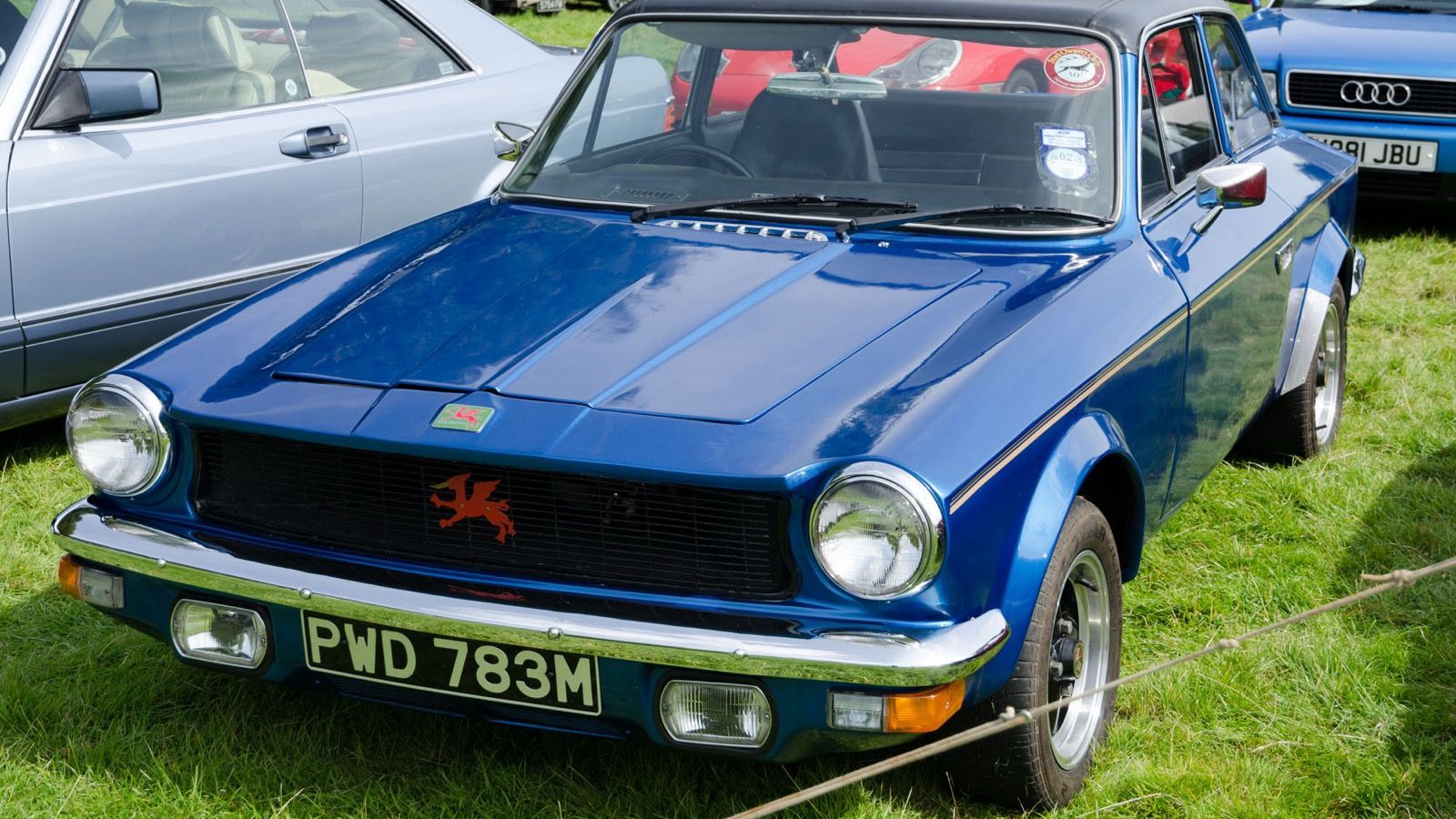 Blue Gilbern Invader Mk III coupé, front three-quarter view, showing the Mk III's smaller grille, quad lamps and wheel spats.
