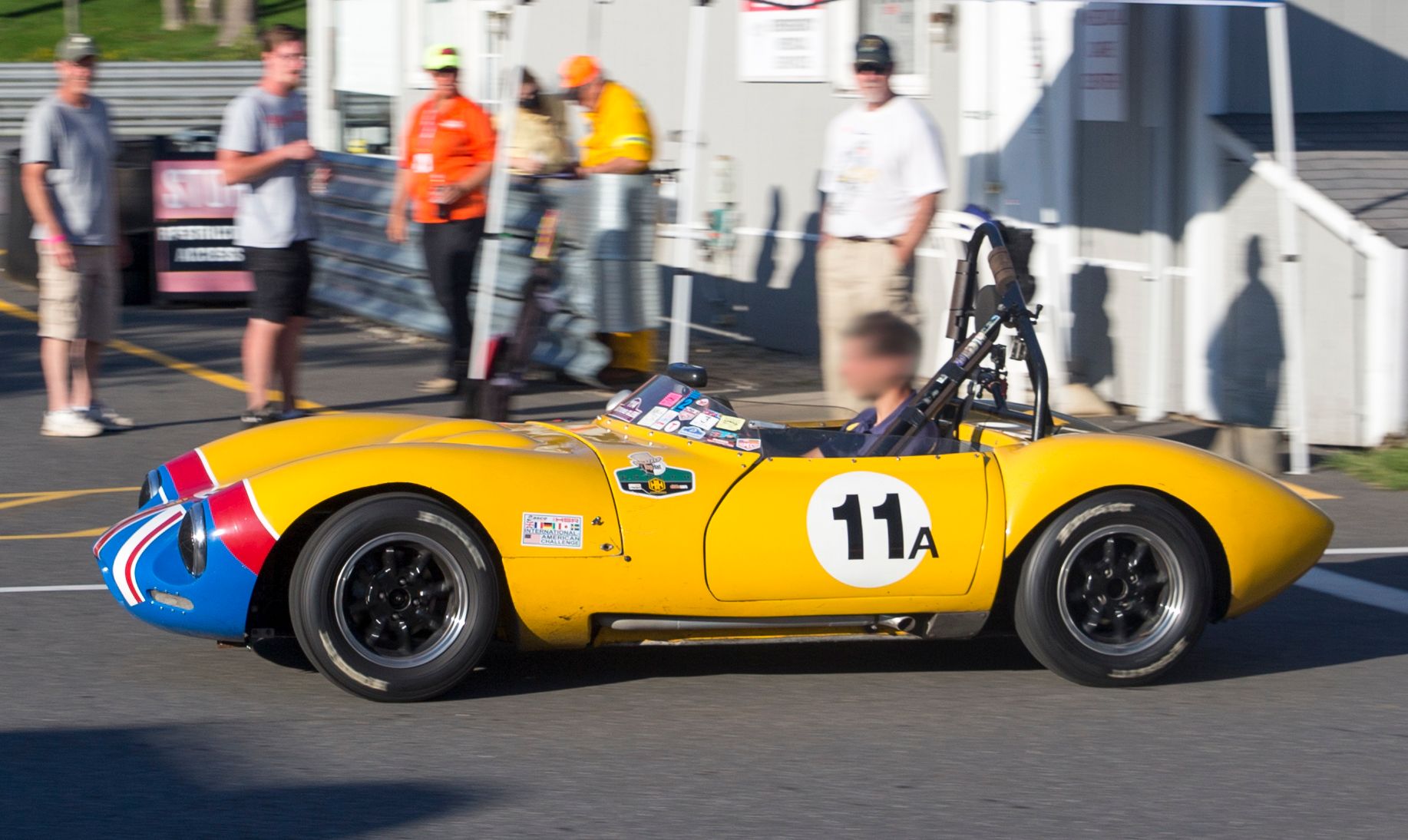 Yellow 1965 Ginetta G4 Series II roadster in side profile at Lime Rock