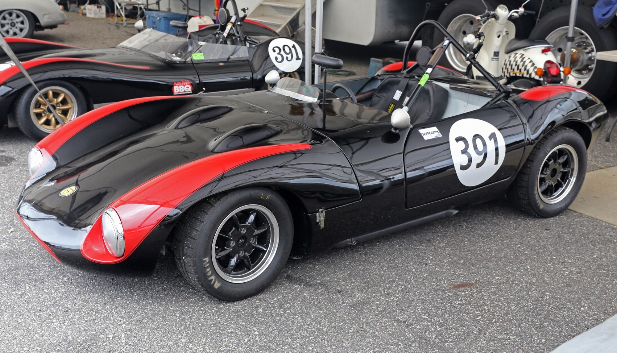 Black and red 1966 Ginetta G4 Series III roadster, front three-quarter view in the Lime Rock paddock