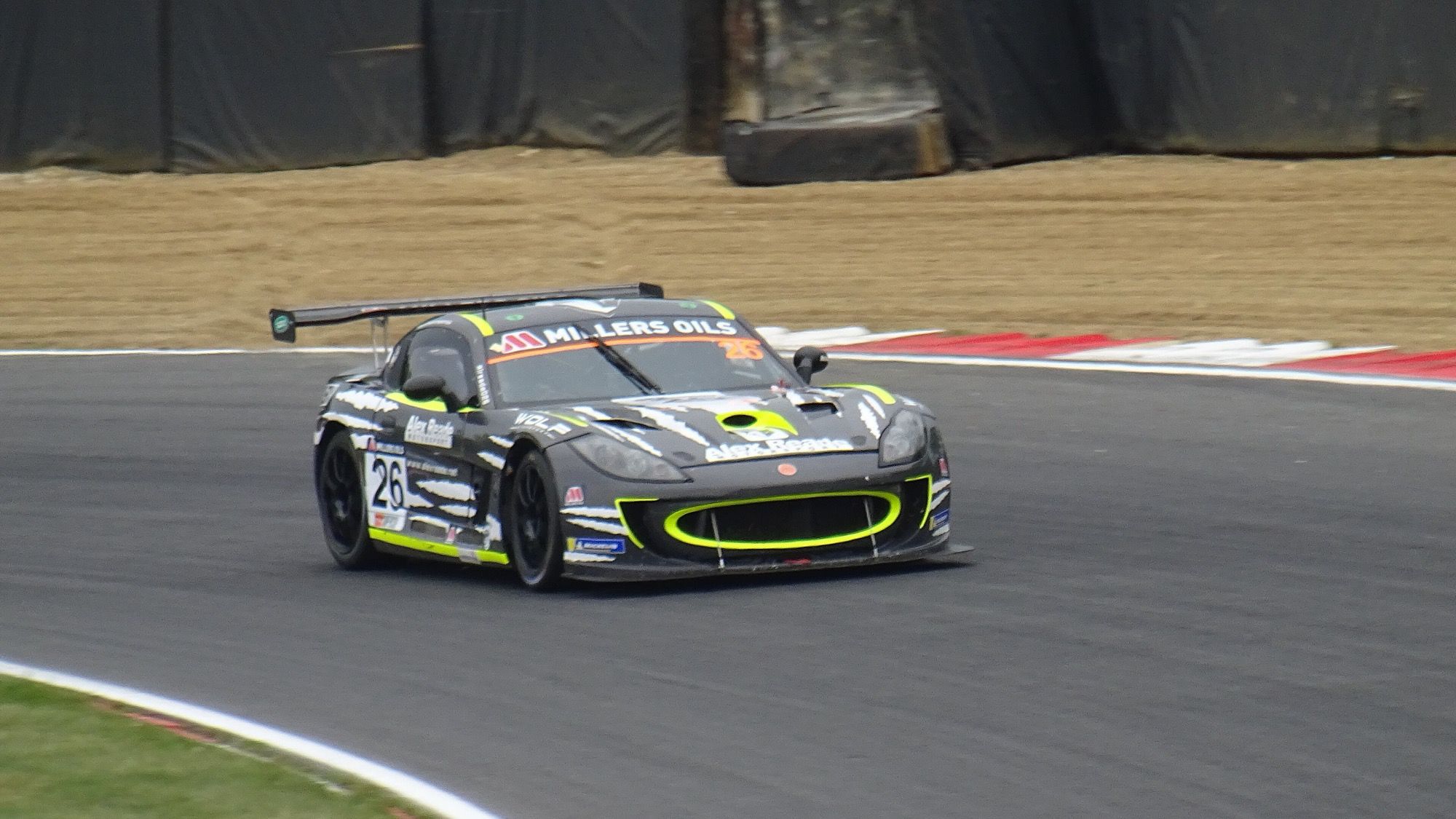 Dark Ginetta G55 GT4 Supercup racer cornering at Brands Hatch, 2022, front three-quarter view