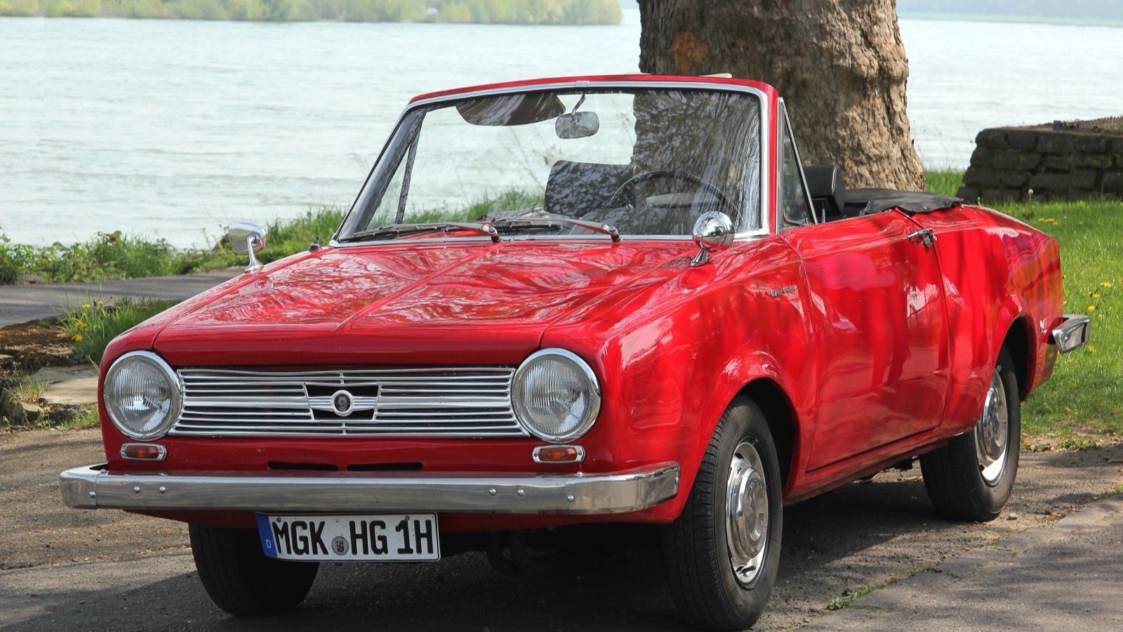 Red 1964 Glas 1204 cabriolet parked beside a river, front three-quarter view