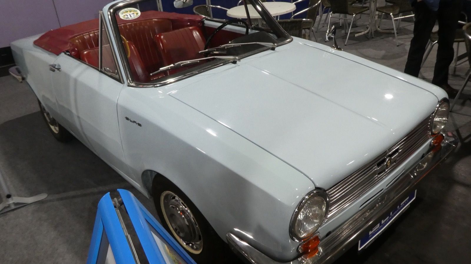 Pale blue Glas S1204 cabriolet with the top down on an indoor show stand, front three-quarter view
