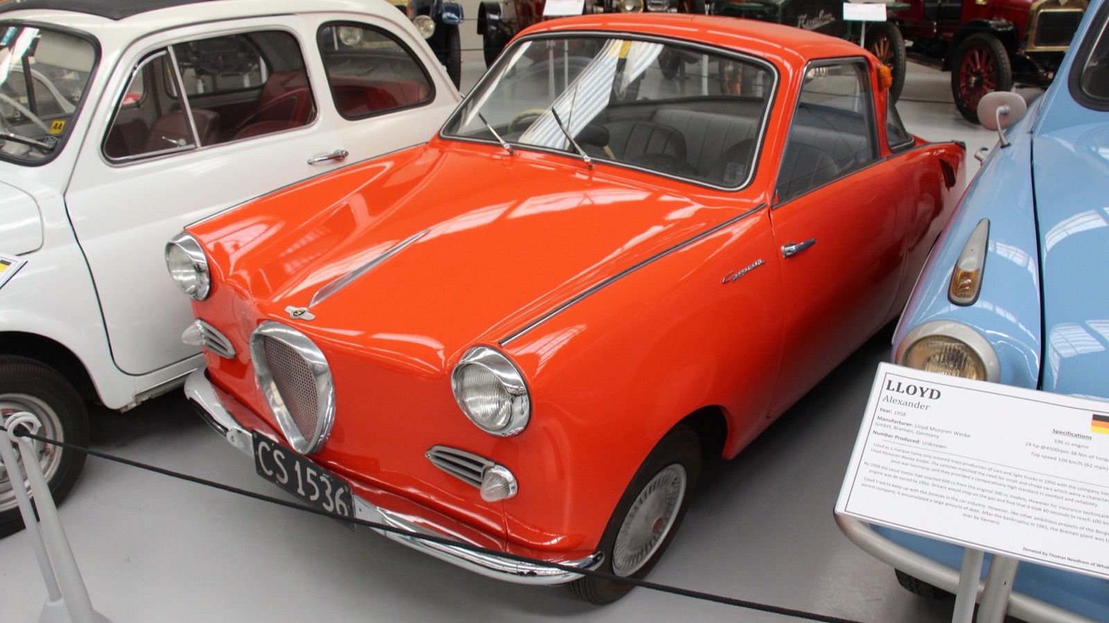 Orange 1957 Goggomobil TS300 coupé in a museum display, front three-quarter view