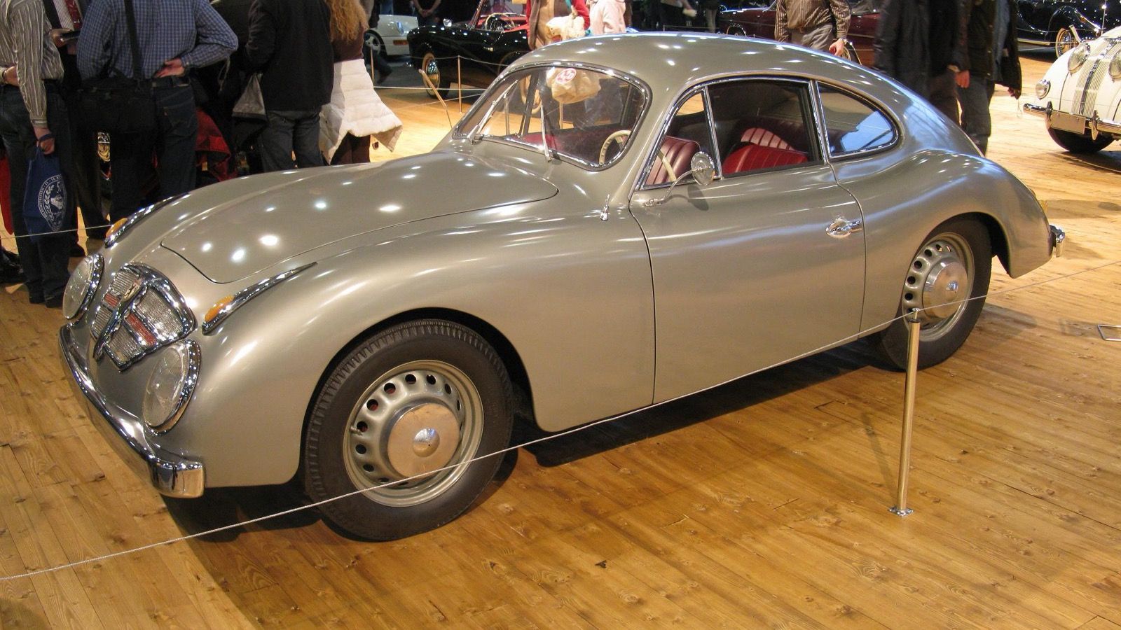 Grey 1952 Goliath GP700 Sport Coupé at an indoor classic car show, front three-quarter view
