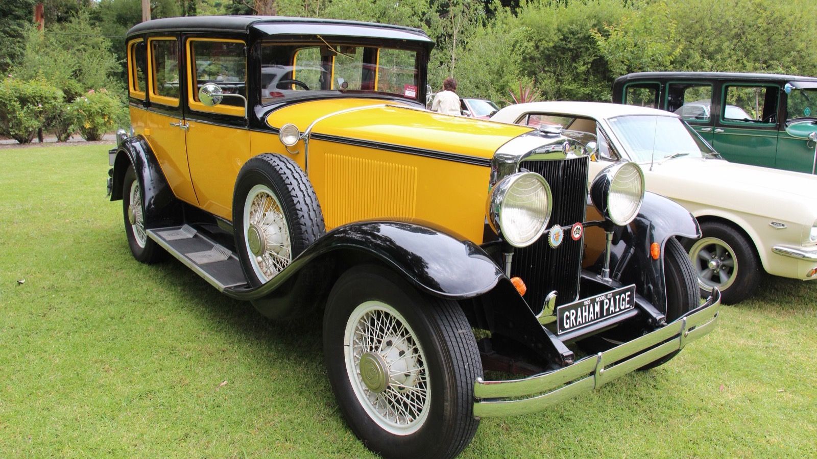 Yellow and black 1929 Graham-Paige Model 827 sedan on grass, front three-quarter view