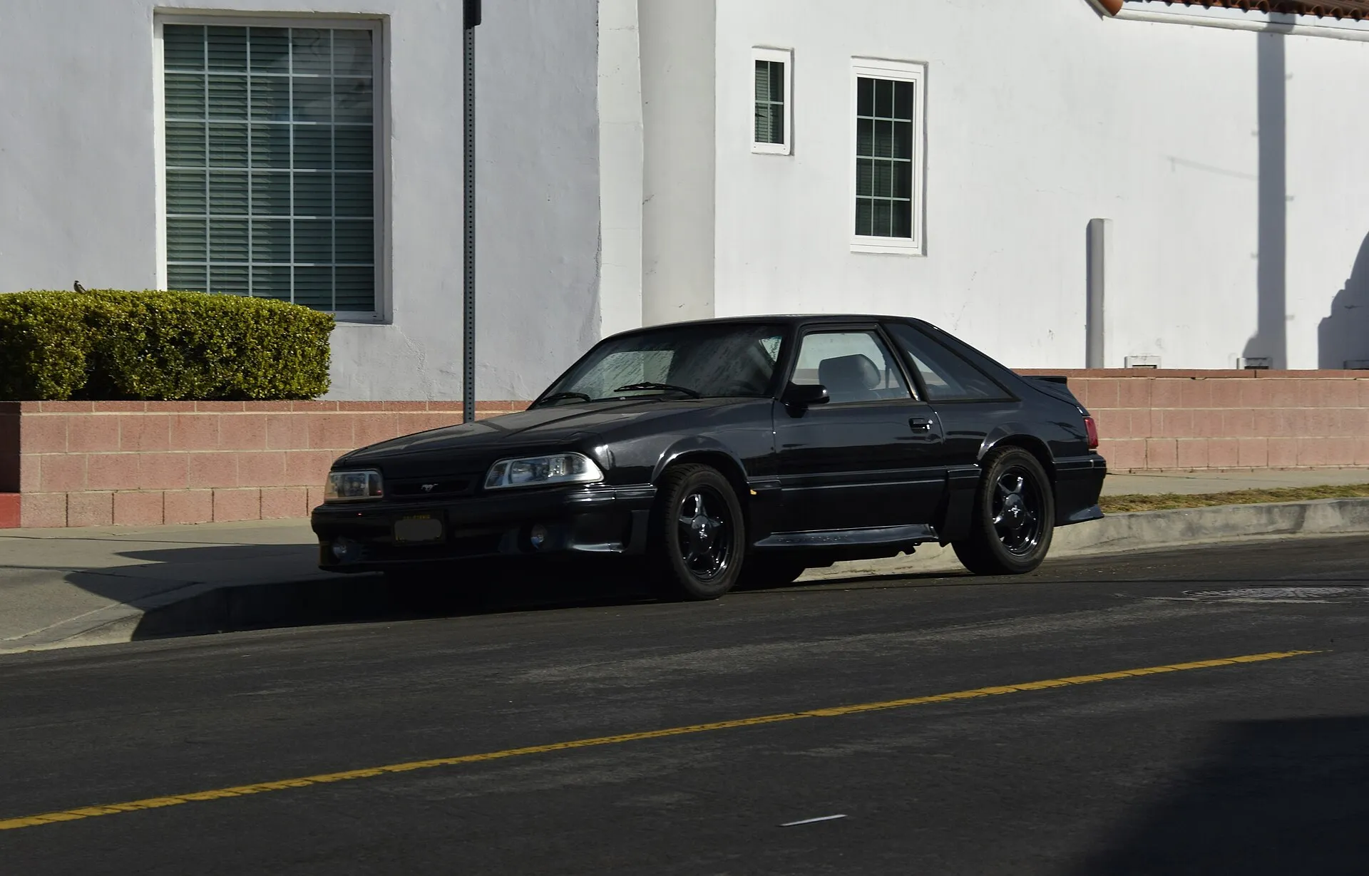 Black 1993 Ford Mustang GT hatchback photographed from the front left