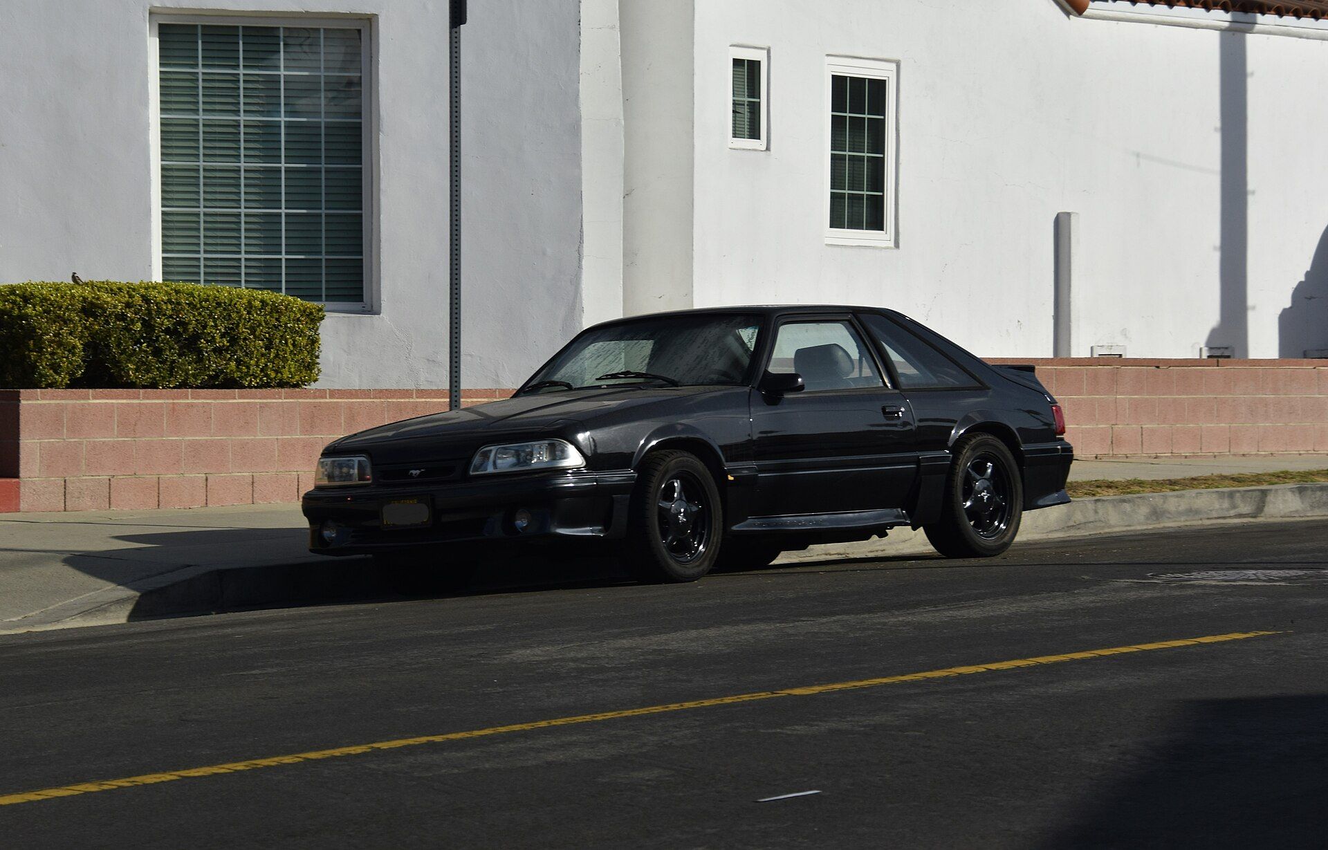 Black 1993 Ford Mustang GT hatchback photographed from the front left