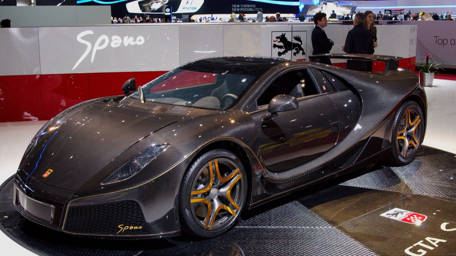 Exposed-carbon GTA Spano with gold wheel accents at the 2013 Geneva Motor Show, front three-quarter view