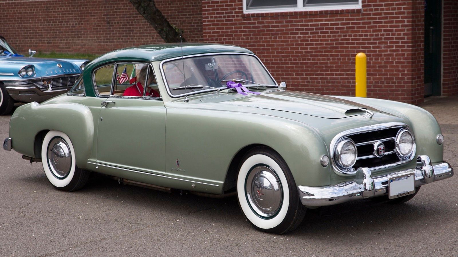 Two-tone green 1954 Nash-Healey Le Mans hardtop coupe parked outdoors, front three-quarter view