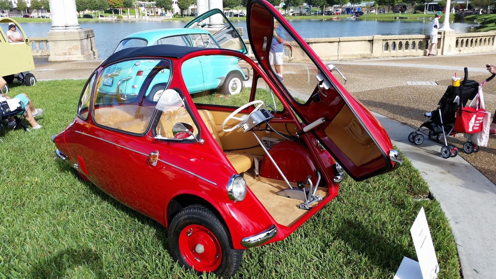 Red 1958 Heinkel Kabine microcar at a car show with its front-hinged door swung open, front three-quarter view