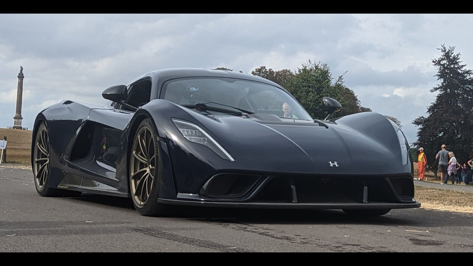 Dark blue 2022 Hennessey Venom F5 coupe on a road, front three-quarter view