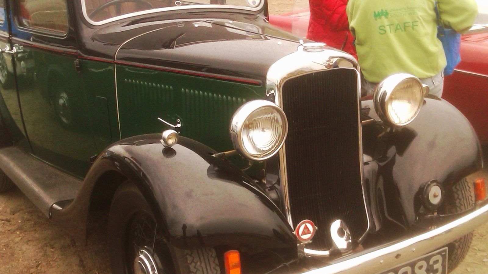 Green and black 1934 Hillman Minx saloon at a car rally, front three-quarter view