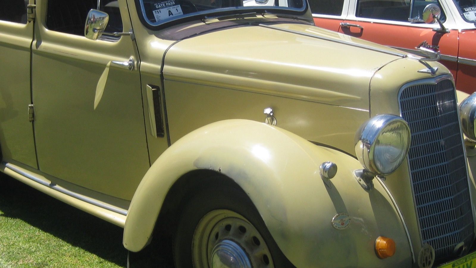 Cream 1937 Hillman Minx saloon with a folding sunroof at a car show, front three-quarter view