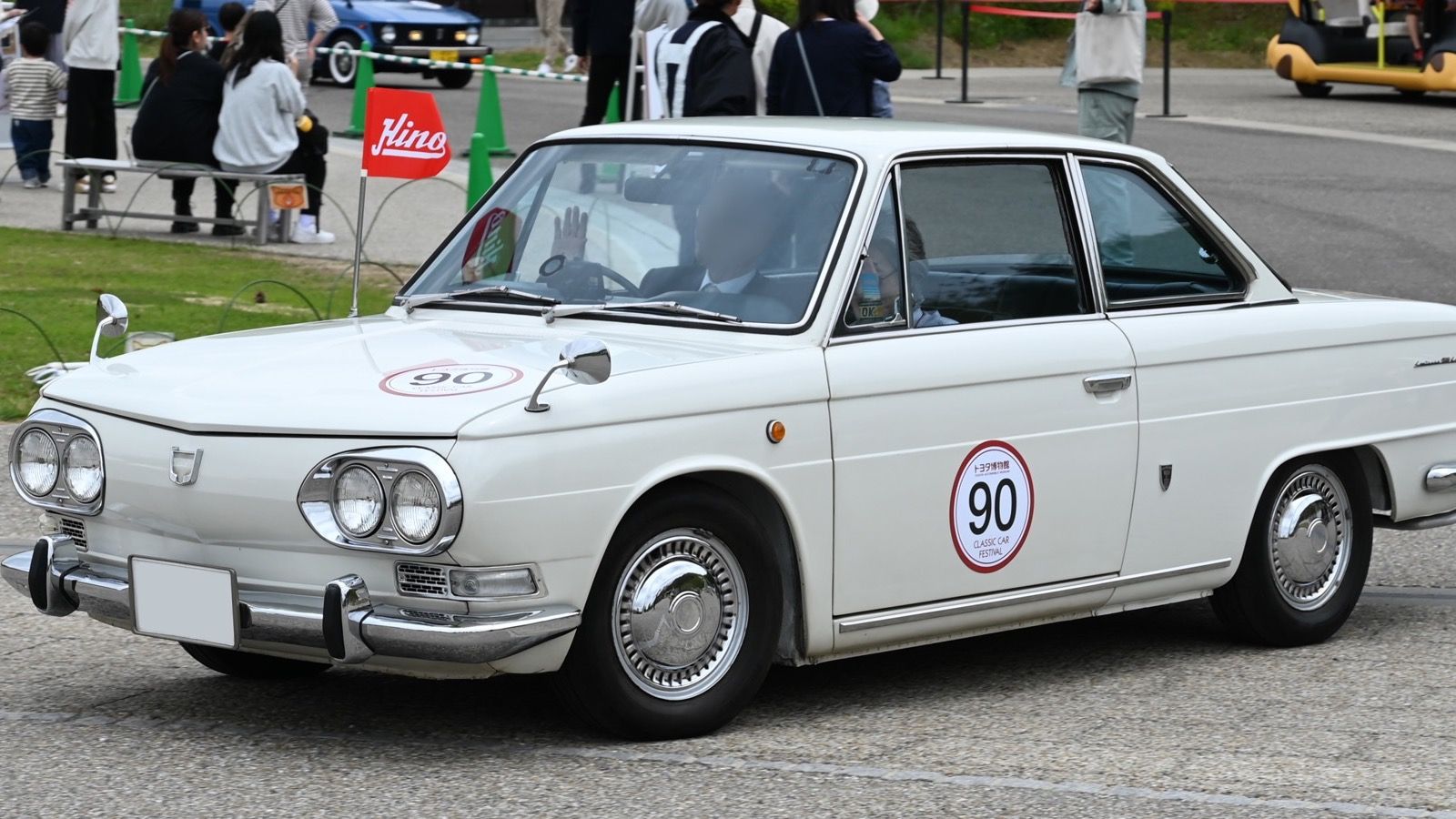 White 1967 Hino Contessa 1300 Coupé at a classic car event, front three-quarter view