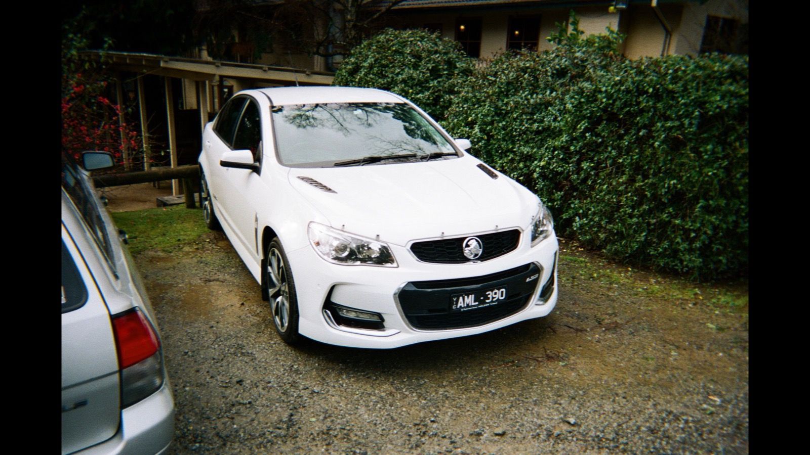 White 2017 Holden VF Commodore sedan parked on gravel, front three-quarter view