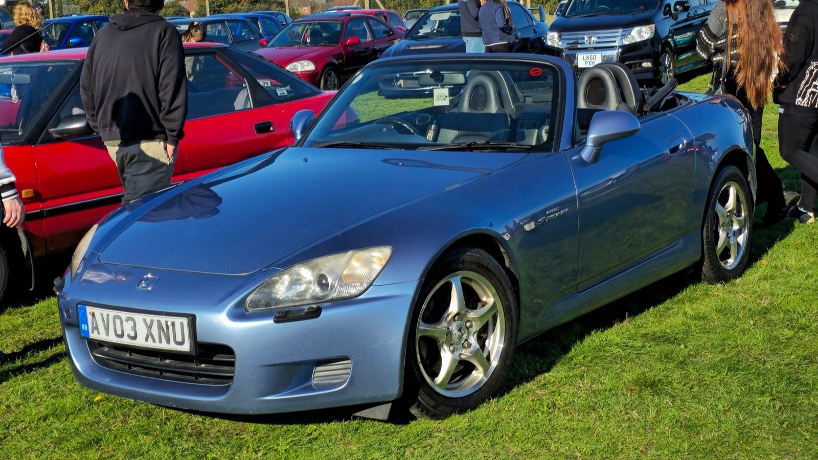 Light blue 2003 Honda S2000 roadster on grass, front three-quarter view