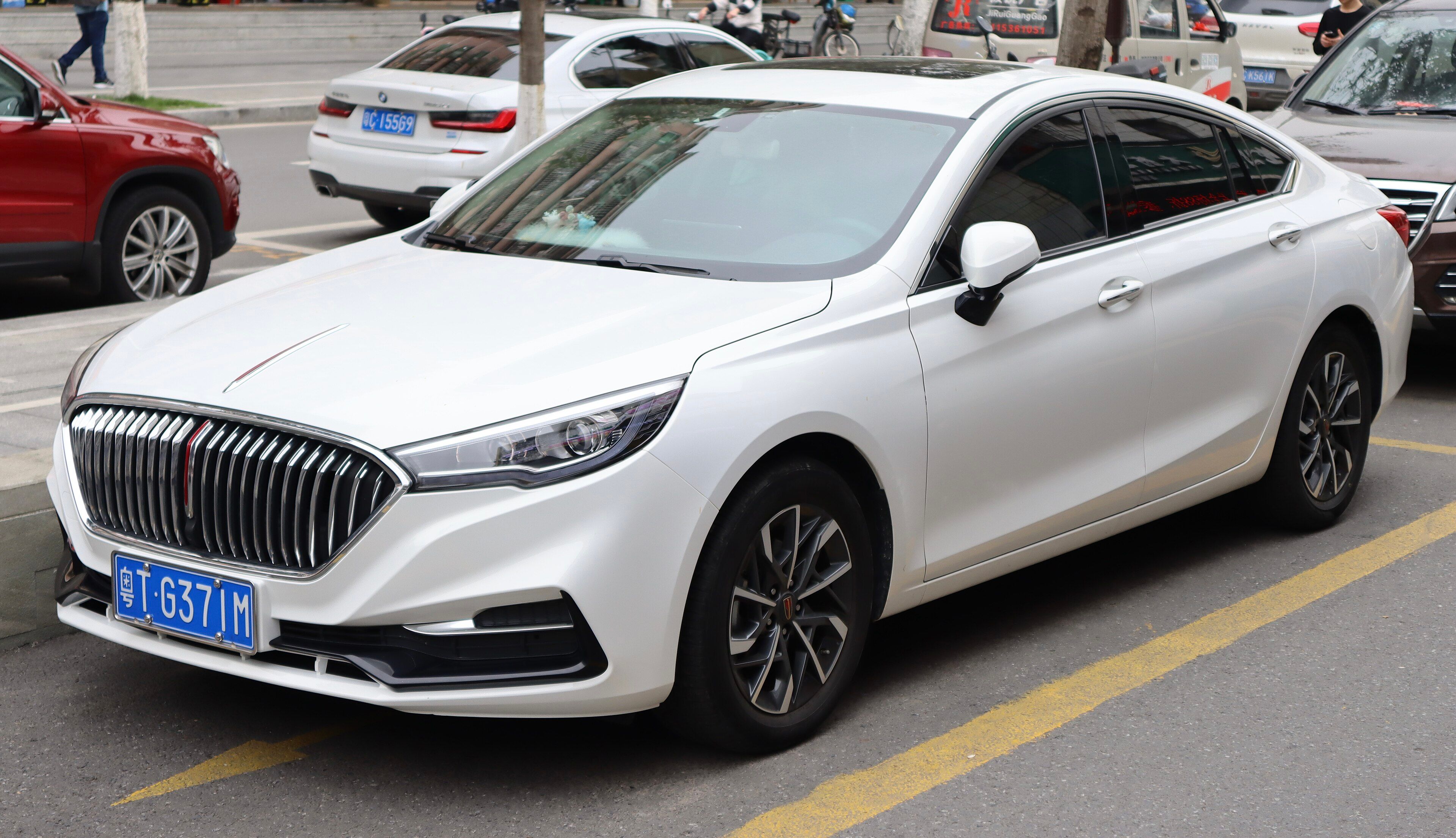 White first-generation Hongqi H5 sedan, front three-quarter view showing the vertical chrome grille.