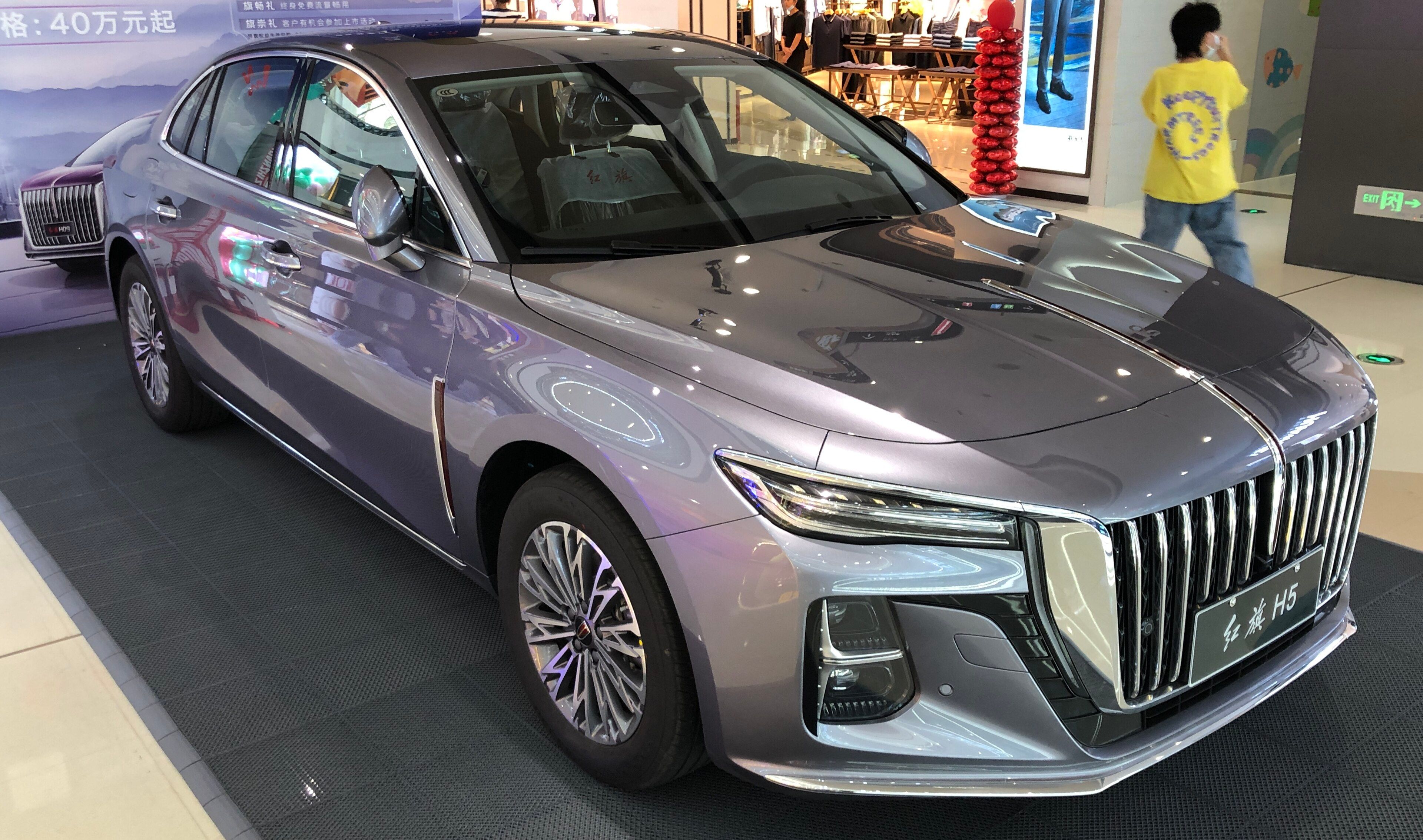 Grey second-generation Hongqi H5 on display indoors, front three-quarter view.