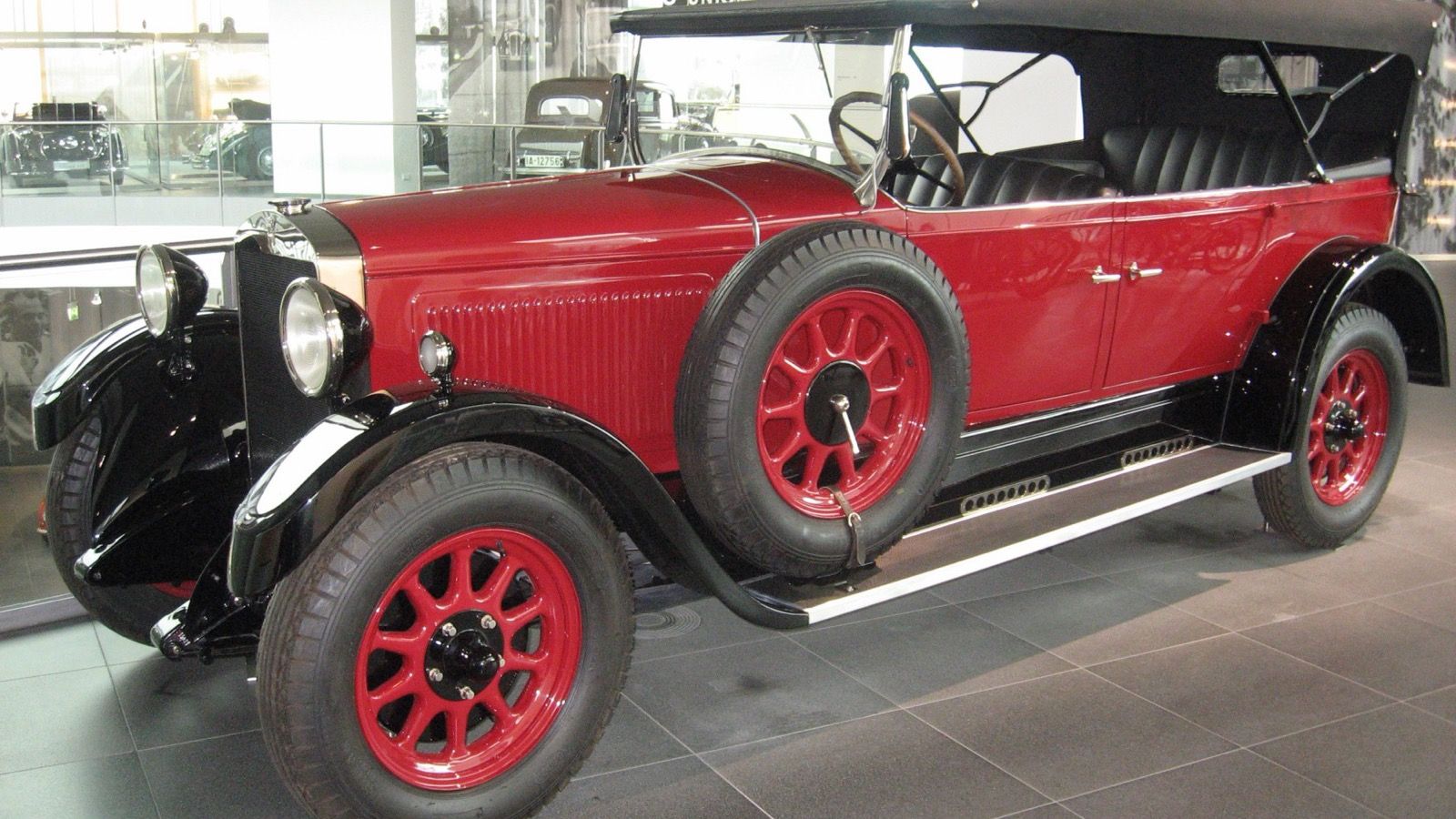 Red and black Horch 303 open touring phaeton on museum display, front three-quarter view