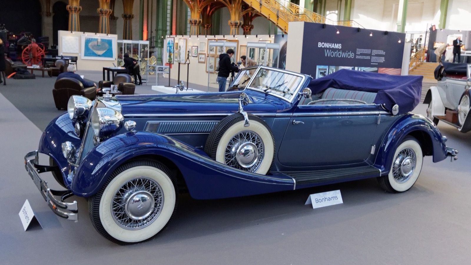 Blue 1938 Horch 853 cabriolet with whitewall tyres at a Paris auction preview, front three-quarter view