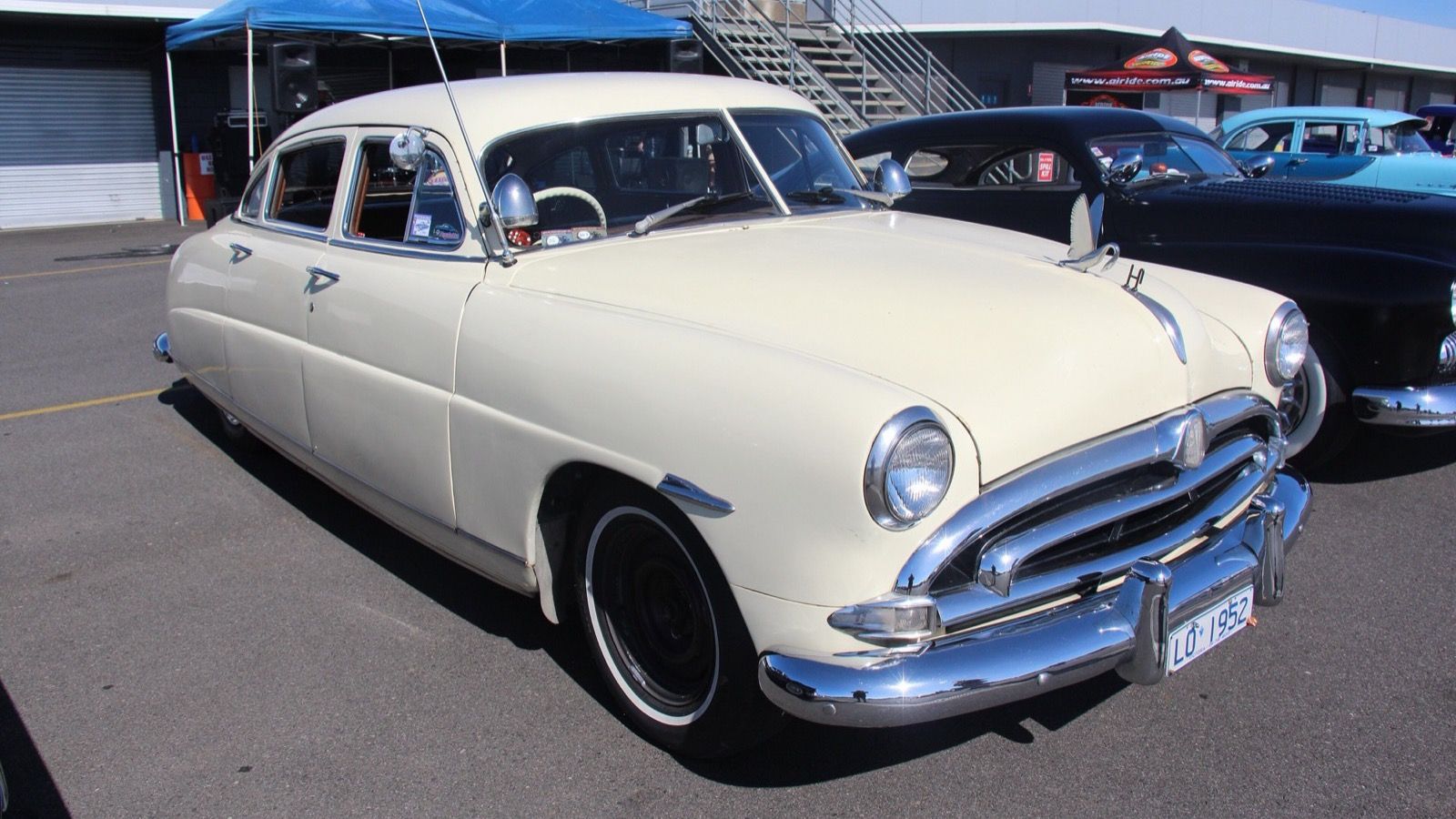 Cream 1952 Hudson Hornet step-down sedan at a car show, front three-quarter view