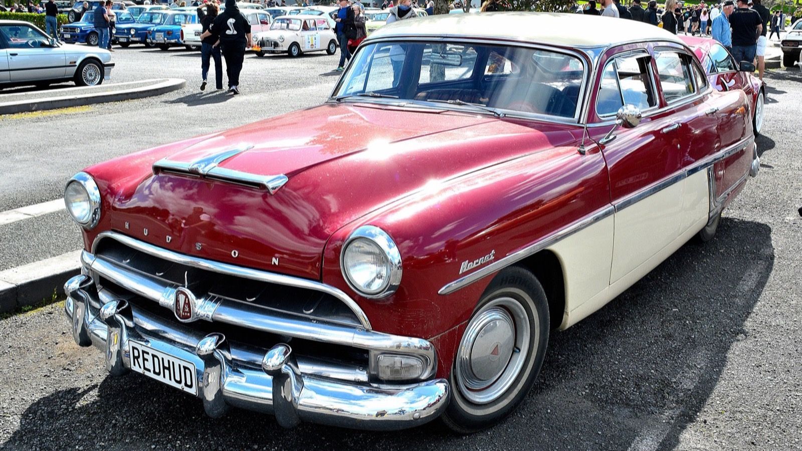 Maroon and cream 1954 Hudson Hornet step-down sedan at a car show, front three-quarter view
