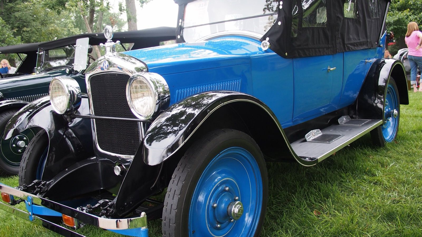 Blue 1924 Hupmobile RS touring car with raised black top at a car show, front three-quarter view