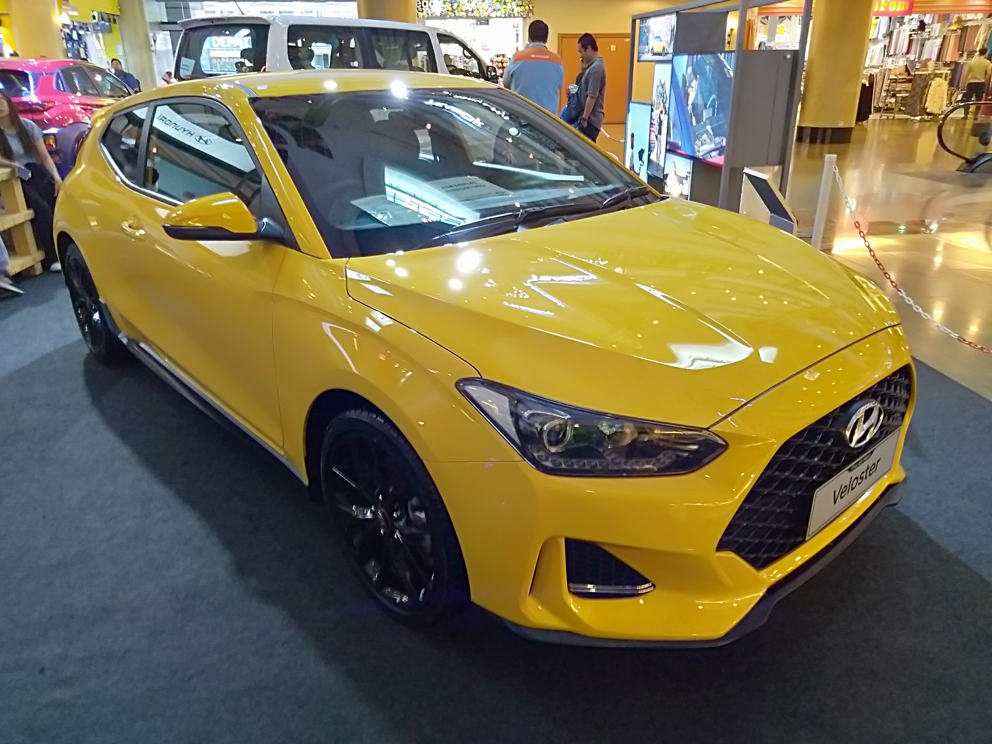 Yellow 2021 Hyundai Veloster 1.6 hatchback on display, front three-quarter view