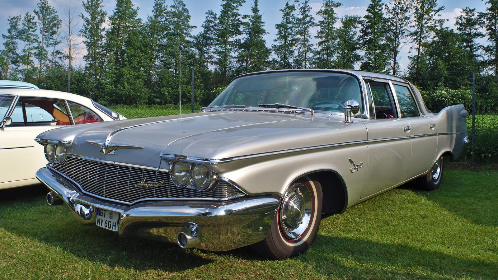 Gold 1960 Imperial four-door hardtop on grass, front three-quarter view.