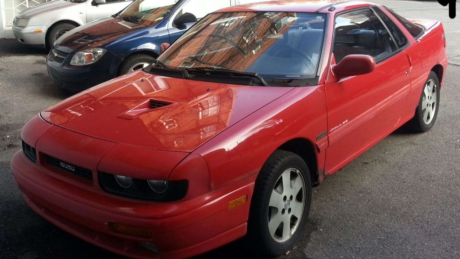 Red 1990 Isuzu Impulse second-generation coupe, front three-quarter view