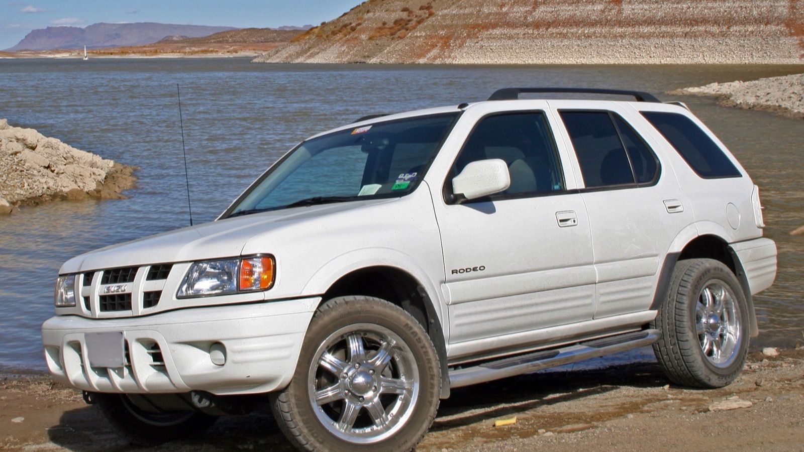 White 2004 Isuzu Rodeo parked by a lake, front three-quarter view