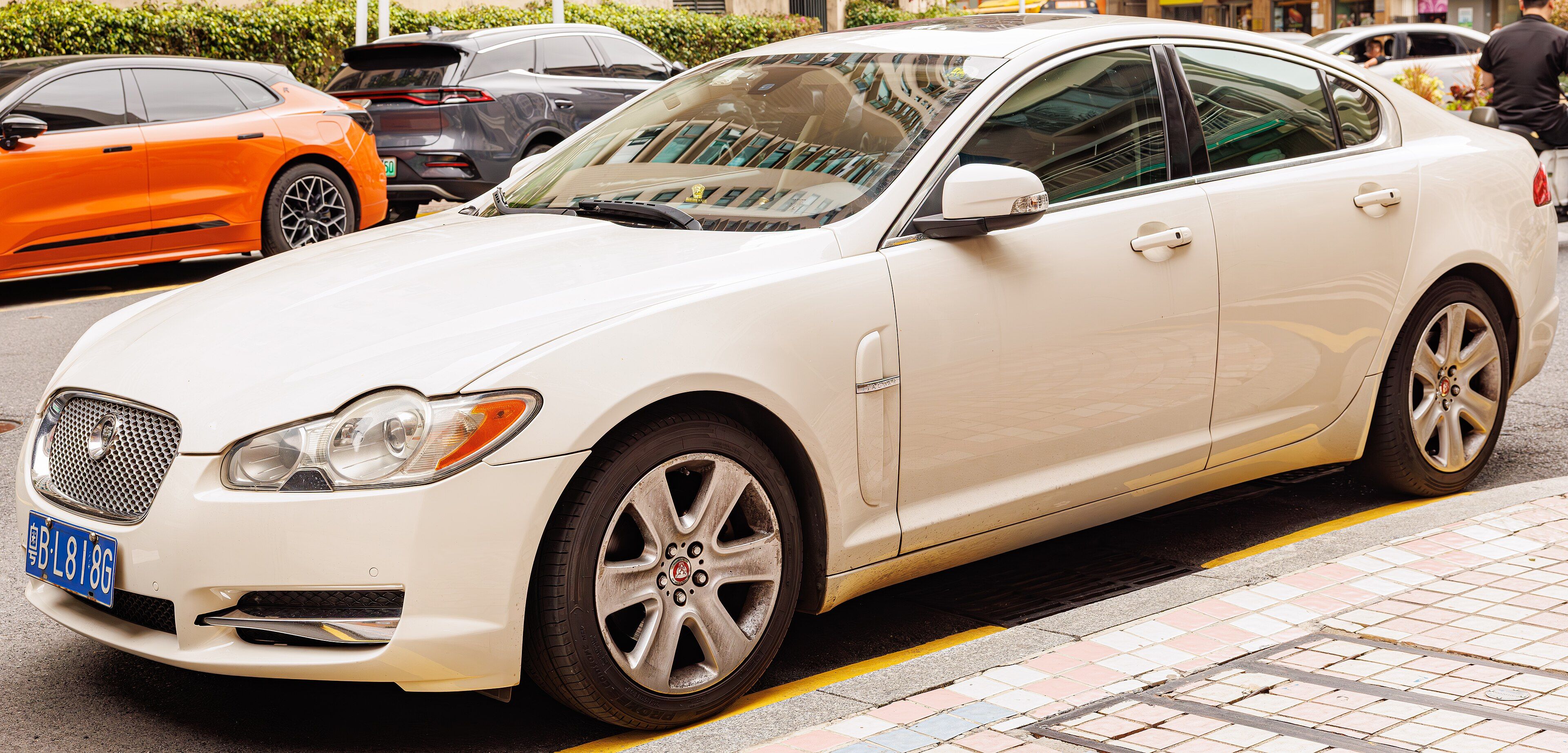White Jaguar XF X250 saloon parked at a kerb, front three-quarter view